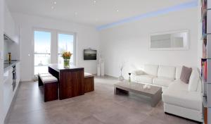 a living room with a white couch and a table at Exklusive Ferienwohnung mit Blick auf den Yachthafen in Peenemünde