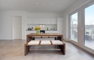 ein Wohnzimmer mit Tisch und Küche in der Unterkunft Exklusive Ferienwohnung mit Blick auf den Yachthafen in Peenemünde