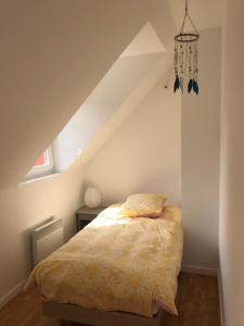 - une chambre avec un lit et un oreiller dans l'établissement L'Avocette en Baie, à Saint-Valery-sur-Somme