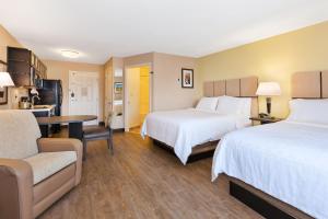 a hotel room with two beds and a table at Candlewood Suites Rocky Mount, an IHG Hotel in Rocky Mount