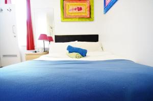 - un lit bleu et blanc avec un oreiller bleu dans l'établissement Astor Hyde Park Hostel, à Londres