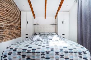 1 dormitorio con 1 cama grande y pared de ladrillo en Precioso estudio con terraza privada en la playa, en Valencia