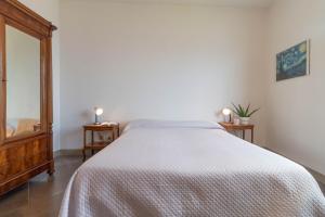 sypialnia z łóżkiem z białą narzutą w obiekcie Mamma Ciccia Holiday Home - Confalonieri w mieście Mandello del Lario
