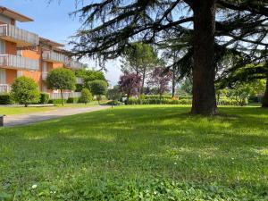 a tree in a park next to a building at Residenza Cappuccini in Peschiera del Garda