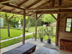 eine hölzerne Pergola mit einer Bank auf einer Terrasse in der Unterkunft APARTMAN SOÓS -- Only for relaxation, not for party! in Siófok