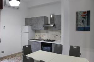 a kitchen with a table and a sink and a refrigerator at Taormina Etna Sea in Piedimonte Etneo