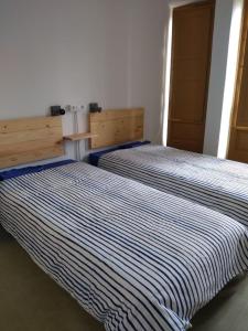 dos camas sentadas una al lado de la otra en una habitación en Albergue Seminario Menor, en Santiago de Compostela