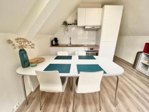 cocina blanca con mesa y sillas en Zandvoort Central Apartment en Zandvoort