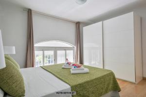 een slaapkamer met een bed met groene lakens en een spiegel bij Alcam Office up in Barcelona