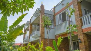 un edificio in mattoni con balconi e alberi di Private Entire 8 BedRooms Garden Pool Villa With Kitchen & BBQ Facilities a Siem Reap