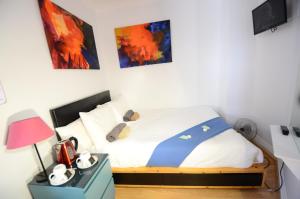 a bedroom with a bed and a table with a lamp at Astor Hyde Park Hostel in London