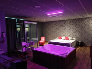 Cette chambre violette comprend un lit et une baignoire. dans l'établissement Motel Los Abedules, à Oviedo