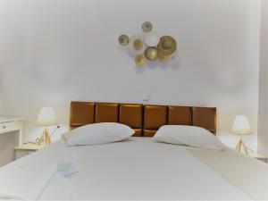 a bedroom with a large white bed with two lamps at Aronis Apartments in Benitses +77 photos