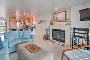 a living room with a blue couch and a fireplace at Ocean Dunes Kure Beach Condo with Balcony and Pool in Kure Beach
