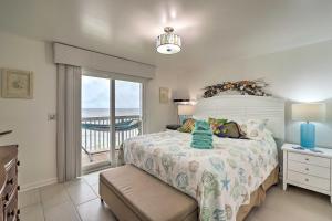 a bedroom with a bed with a view of the ocean at Ocean Dunes Kure Beach Condo with Balcony and Pool in Kure Beach