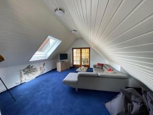 een zolderkamer met een bank en een raam bij Untersee - Appartements in Moos