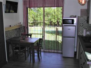 una cucina con tavolo e una sala da pranzo con finestra di le gite de léonard a Castelnau-dʼEstrétefonds