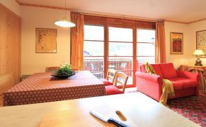 salon z czerwoną kanapą i stołem w obiekcie Family Apartment FUCHS Bad Kleinkirchheim w mieście Bad Kleinkirchheim