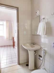 a white bathroom with a sink and a toilet at Amarante Hotel in Juazeiro