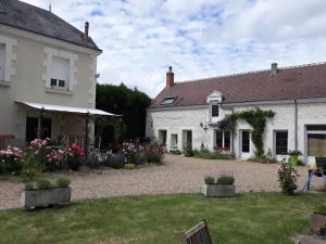a white house with a garden in front of it at Atypiques Confitures, Chambres d'Hôtes in Couffy