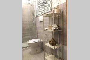 a bathroom with a toilet and a glass shelf at Via Sparano Suite in Bari +14 photos