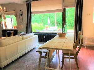 a living room with a white couch and a table at Cosy House in Otterlo