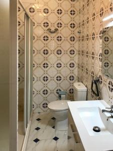 baño con aseo y pared de azulejos en Casa de la Abuela, en Fabero
