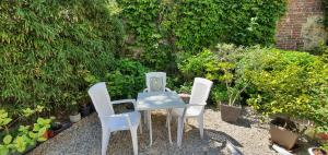 een tafel en vier stoelen in de tuin bij Hôtel de la Côte Fleurie in Deauville