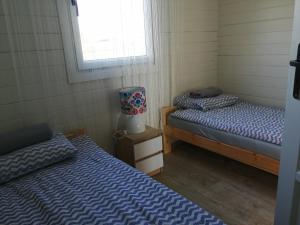 two twin beds in a room with a window at Domek LENA in Giżycko
