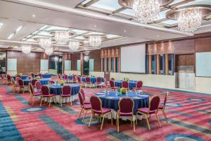 a conference room with tables and chairs and a projection screen at Crowne Plaza Amman by IHG in Amman +182 photos