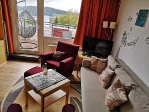 a living room with a couch and chairs and a balcony at 2 Raum Ferienwohnung Sonnenschein in Sankt Englmar