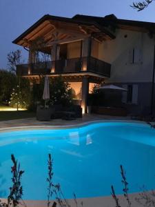 a large blue swimming pool in front of a house at Michela BB & Relais in Lonato