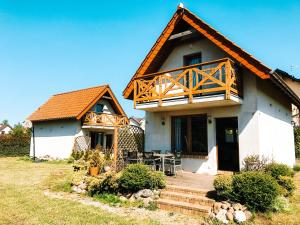 a house with a deck on the front of it at Fajne Domki in Władysławowo-Chłapowo