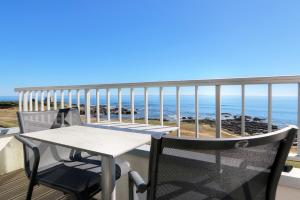 a table and chairs on a balcony overlooking the ocean at Hôtel La Petite Sirène Quiberon in Quiberon