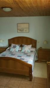 ein Schlafzimmer mit einem Bett mit einem Kopfteil aus Holz in der Unterkunft Casa de pueblo en Galicia, A Forneira in Leiro