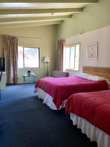 a hotel room with two beds with red sheets at Stevenson’s Inn in Kings Beach