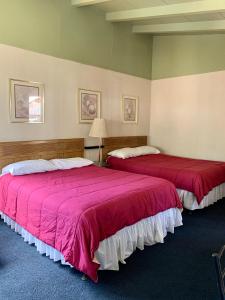 Duas camas num quarto com edredões vermelhos em Stevenson’s Inn em Kings Beach