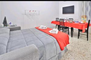 サレルノにあるCasa vacanza Arcangeliのベッド1台、テーブル(赤毛布付)が備わる客室です。