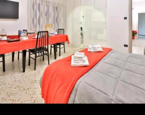 una camera con un tavolo e una coperta rossa su un letto di Casa vacanza Arcangeli a Salerno