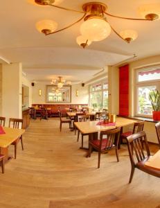 uma sala de jantar com mesas e cadeiras de madeira em Stumbergers Hotel em Cochem