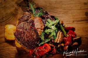 een bord met vlees en groenten op tafel bij Hotel President in Kock