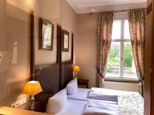 a hotel room with two beds and a window at Hotel Kronprinz in Falkensee