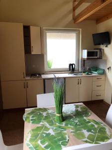 a kitchen with a table with a vase of flowers on it at Domki DRAGON Łeba in Łeba