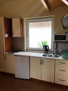 a kitchen with a sink and a window at Domki DRAGON Łeba in Łeba +10 photos