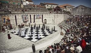 uma multidão de pessoas à volta de um tabuleiro de xadrez em Motel Cancun Barbadas-Ourense em Os Fornos