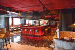 a bar in a restaurant with red bar stools at Fletcher Wellness-Hotel Kamperduinen in Kamperland
