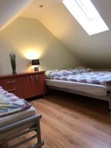 a attic bedroom with two beds and a skylight at Domki DRAGON Łeba in Łeba