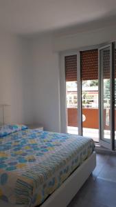 a bedroom with a bed and two sliding glass doors at La villetta vista mare in Bisceglie