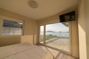 1 dormitorio con cama y ventana grande en Heaven's Gate Apartment Fonyód en Fonyód
