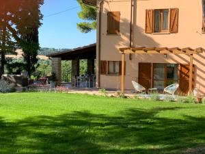 Villa Monte Illuminato في فانو: منزل مع ساحة مع عشب أخضر